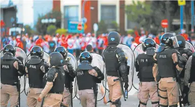  ?? AP/ERALDO PERES ?? Police confront River Plate fans on the eve of last year’s postponed second leg Copa Libertador­es clash with Boca Juniors.