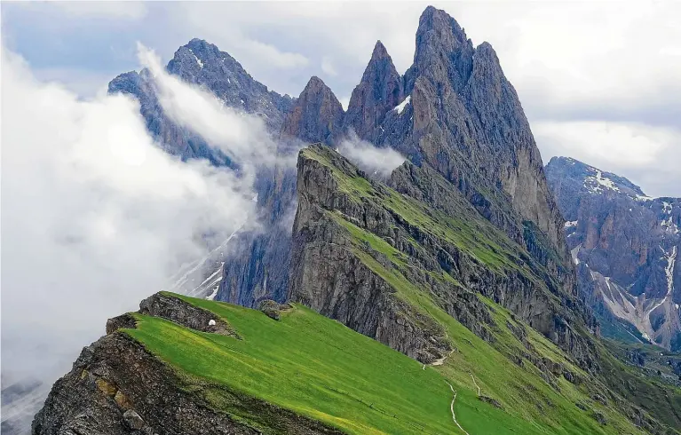  ??  ?? A blanket of clouds rolls in from the Funes valley and banks up against the pinnacles of the Puez-Odle group of mountains.