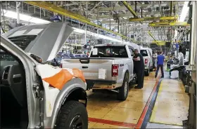  ?? CARLOS OSORIO — THE ASSOCIATED PRESS ?? United Auto Workers assemblyme­n work on a Ford F-150trucks being assembled at the Ford Rouge assembly plant in Dearborn, Mich., in this 2018 photo.