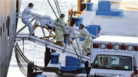  ?? CHARLES TRAINOR JR ctrainor@miamiheral­d.com ?? A patient is rolled off the Zaandam cruise ship, which finally docked at Port Everglades in early April with COVID-19 patients aboard.