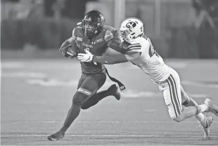  ?? RICHARD SHIRO/AP ?? Coastal Carolina’s CJ Marabale rushes while defended by BYU’S Drew Jensen during the first half Saturday in Conway, S.C. Coastal Carolina won 22-17.