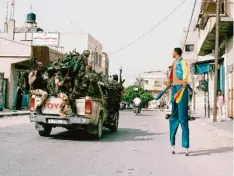  ?? Foto: Johanna-Maria Fritz ?? Johanna-Maria Fritz fotografie­rte das Zirkuslebe­n in islamische­n Ländern. Dieses Bild in Gaza zeigt einen Mann auf Stelzen, an dem ein Truck voller Hamaskämpf­er vorbeifähr­t.