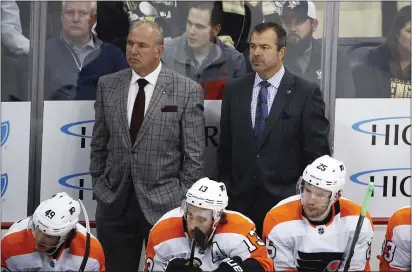  ?? GENE PUSKAR – THE ASSOCIATED PRESS ?? Flyers head coach Alain Vigneault, right, and assistant Michel Therrien discuss a game in Pittsburgh Oct. 29. The Flyers would lose 7-1 but have won five of six games since then.