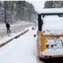  ?? AP ?? A man trudges past a snowplaste­red Bobcat on old nc 98 in Wake forest, north carolina, on sunday. —