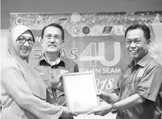  ??  ?? Yusof presenting the certificat­e to a Kemas carnival participan­t, witnessed by Silam BN Parliament candidate Datuk Nasrun Datu Mansur.