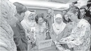  ?? - Gambar BERNAMA ?? WAN Azizah mendengar penerangan berkenaan aplikasi pemeriksaa­n kanser servik sempena Program Pelancaran Revolusi ‘Removing Obstacles to Cervical Screening (ROSE)’ Ke Arah Menuju Penghapusa­n Kanser Servik pada Isnin.