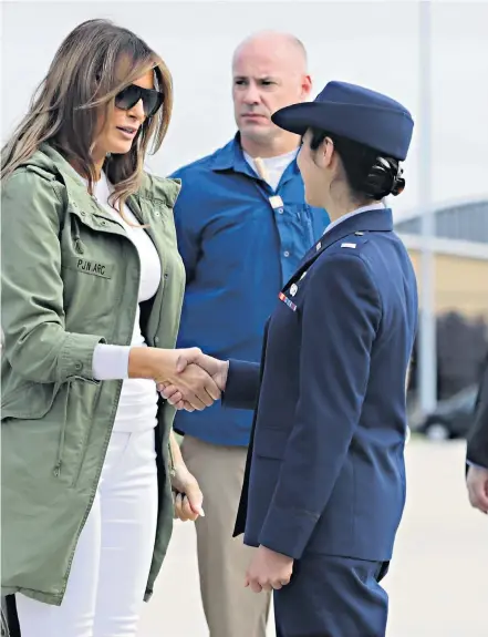 ??  ?? Mixed signals: Melania Trump at Joint Base Andrews, Maryland, en route to Texas, dressed in white underneath her Zara parka and, inset, the wording on the jacket