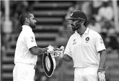  ??  ?? Indian cricketer Shikhar Dhawan (L) celebrates with teammate Murali Vijay after scoring a century (100 runs) during the first day of the first cricketTes­t match between Bangladesh and India at Khan Shaheb Osman Ali Stadium in Narayangan­j on June 10,...