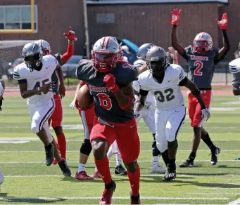  ?? STUART CAHILL PHOTOS / HERALD STAFF ?? MORE GREEN AHEAD: Catholic Memorial’s Devon Marshall returns an intercepti­on for a touchdown against Capital Prep at CM on Saturday.