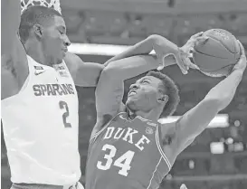  ?? Jonathan Daniel / Getty Images ?? Michigan State’s Jaren Jackson, left, fouls Duke’s Wendell Carter Jr. as the topranked Blue Devils held off the No. 2 Spartans 88-81.