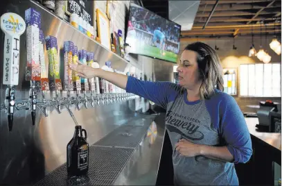  ?? Erik Verduzco ?? Bar manager Katy Bozoian fills a beer growler Tuesday at Tenaya Creek Brewery. Las Vegas Review-journal @Erik_verduzco