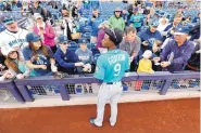  ?? CHARLIE NEIBERGALL/ASSOCIATED PRESS ?? Seattle’s Dee Gordon gives autographs before a spring training game last Friday. Gordon, a Gold Glove second baseman, will be playing center field for the Mariners.