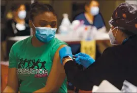  ?? DYLAN BOUSCHER — STAFF PHOTOGRAPH­ER ?? Ezuma Ekomo Ble, a senior at Milpitas High School, receives her COVID-19 vaccine in a locker room at Levi’s Stadium in Santa Clara on Tuesday.