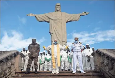  ?? AP-Silvia Izquierdo ?? Catholic Priest Omar, center, leads a prayer as soldiers pause from disinfecti­ng the Christ the Redeemer area, closed because of the coronaviru­s pandemic, in Rio de Janeiro, Brazil, on Aug. 13.