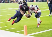  ?? DAVID J. PHILLIP/ASSOCIATED PRESS ?? Houston quarterbac­k Deshaun Watson (4) dives past New England’s Elandon Roberts to score a touchdown Sunday night.