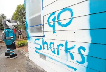  ?? DAN HONDA/STAFF PHOTOS ?? The final touches still need to be made on a newly painted home in Los Gatos on Wednesday. Robert Beech won a contest to have his home painted the Shark's team color, teal, in support of their favorite NHL team. This is part of the Sharks' "Sharks For...