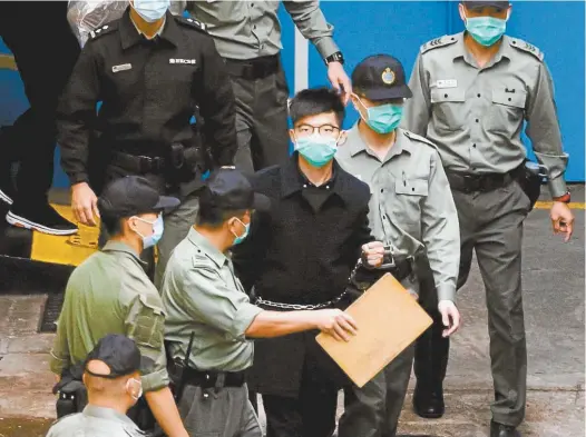  ?? Reuters / Tyrone Siu ?? Joshua Wong walks to a prison van to head to court with other pro-democracy activists in Hong Kong last week.