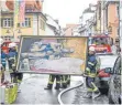  ?? FOTO: FELIX KÄSTLE ?? Feuerwehrl­eute tragen Kunstwerke aus der brennenden Kirche Sankt Jodok