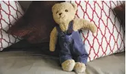  ??  ?? A stuffed bear sits on a couch in a therapy room at Huckleberr­y House to welcome children in need.