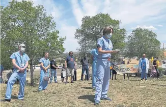  ??  ?? Medical staff from Rehoboth McKinley Christian Hospital, including Chief Medical Officer Val Wangler, center, hold a protest over working conditions and depleted staff in Gallup, N.M., on May 8.