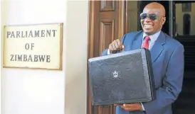  ?? Picture: REUTERS ?? MAKING THE CASE: Zimbabwe Finance Minister Patrick Chinamasa presents the briefcase carrying the 2016 budget in Harare on Thursday
