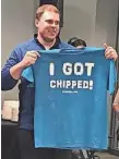  ?? LAURA SCHULTE, WAUSAU DAILY HERALD ?? An employee at Three Square Market in River Falls, Wis., holds up his “I Got Chipped” T-shirt at a company function where microchips were embedded in willing employees.