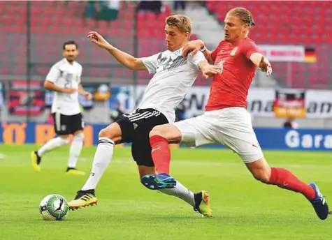  ?? AFP ?? Austrian defender Sebastian Proedl (right) and Germany’s Nils Petersen vie for the ball during the internatio­nal friendly in Klagenfurt, Austria, on Saturday. The defending champions suffered a shock 2-1 loss in preparatio­n for World Cup.