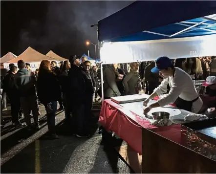  ?? — AP ?? From home sweet home: A man preparing a large crepe used in a Burmese dish sold at the Queens night market which is modelled on traditiona­l night markets found in Asia.