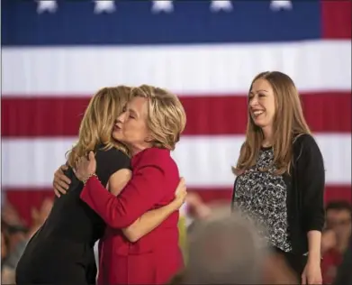  ?? PHOTOS BY RICK KAUFFMAN — DIGITAL FIRST MEDIA ?? Hillary Clinton hugs actress Elizabeth Banks, left, as Chelsea Clinton waits her turn Tuesday at the Haverford Community Rec Center.