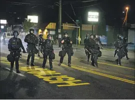  ?? Dave Killen Oregonian ?? POLICE on the streets of Portland, Ore., this week. Officers have arrested over 400 people since late May. U.S. agents arrested at least 94 people through July 30.