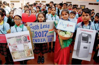  ?? PTI ?? School students hold placards at a painting competitio­n on ‘Cash Less India’ in Ahmedabad on Saturday. —