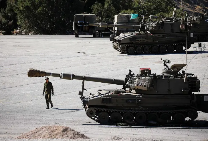  ?? (Reuters) ?? A SOLDIER walks next to a tank on the Golan.