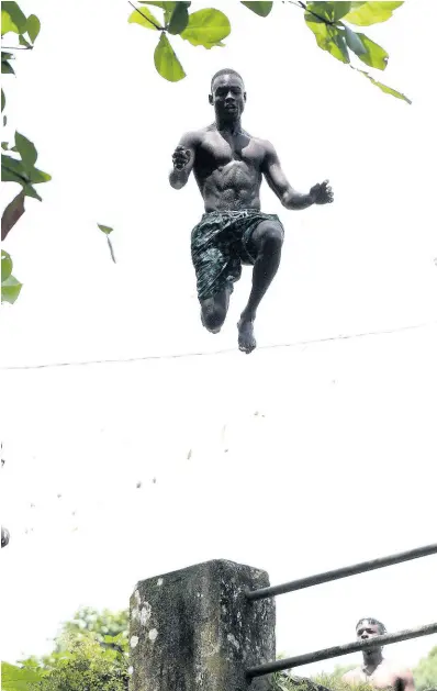  ?? IAN ALLEN/PHOTOGRAPH­ER ?? Davion Sibley, a member of the Palmetto Grove Divers, leaps from a bridge into a river in the St Mary community recently. Look out for a feature on their death-defying dives in Friday’s Gleaner.