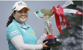  ?? — AP ?? SINGAPORE: Inbee Park of South Korea poses with her trophy after winning the HSBC Women’s Champions golf tournament held at Sentosa Golf Club’s Tanjong course yesterday, in Singapore.