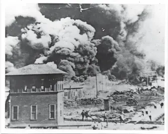  ??  ?? Smoke rises north of Greenwood Avenue from Hartford Avenue, in Tulsa, Okla. on June 1, 1921. Images from The University of Tulsa’s McFarlin Library archives show scenes from the Tulsa race massacre of 1921 when a white mob destroyed the 35-block “Black Wall Street” – a thriving business district in Tulsa. The number of deaths has never been confirmed, but estimates vary from about three dozen to 300 or more. THE UNIVERSITY OF TULSA, MCFARLIN LIBRARY ARCHIVES