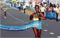  ?? Atiq-ur-Rehman/Gulf News ?? Worknesh Degefa from Ethiopia wins the women’s race with a time of 2:22:36.