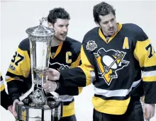 ?? GENE J. PUSKAR/THE ASSOCIATED PRESS ?? Pittsburgh Penguins’ captain Sidney Crosby, left, and Evgeni Malkin pose with the Prince of Wales Trophy after beating the Ottawa Senators 3-2 in the second overtime of Game 7 to win the Eastern Conference final in Pittsburgh, last Thursday.