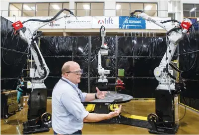  ?? STAFF PHOTOS BY C.B. SCHMELTER ?? Two people work on using a large scale cement 3D printer at the Manufactur­ing Demonstrat­ion Facility. Manufactur­ing Systems Research Group Leader Lonnie Love talks about the “MedUSA” 3D printer while touring the Manufactur­ing Demonstrat­ion Facility on the Hardin Valley Campus of the Oak Ridge National Laboratory in Knoxville, Tennessee.