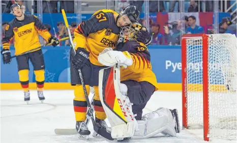  ?? FOTO: ANGELIKA WARMUTH ?? Nach dem verlorenen Eishockeyf­inale gegen die Olympische­n Athleten aus Russland musste Marcel Goc (Mitte) seinen Torhüter Danny Aus den Birken trösten. Die DEB-Auswahl führte 55 Sekunden vor Schluss 3:2 und unterlag in der Verlängeru­ng.