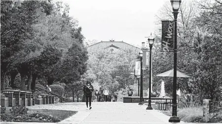  ?? ANDREW SPEAR/THE NEW YORK TIMES ?? Students make their way across campus this month at OhioWesley­an University in Delaware, Ohio. The university is eliminatin­g 18 majors.