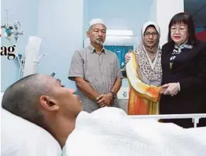  ?? PIC BY AIZUDDIN SAAD ?? Deputy Higher Education Minister Datuk Dr Mary Yap Kain Ching (right) visiting Muhammad Haziq Redzuan at Kuala Lumpur Hospital yesterday. With her are Haziq’s parents Redzuan Kamaruddin (left) and Hasmah Yusuf.