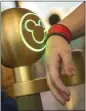  ?? PHOTO BY KENT PHILLIPS ?? ANAHEIM
A guest uses an electronic bracelet to enter Magic Kingdom in Florida, where Disney parks have employed the bands for years.