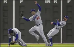  ?? The Associated Press ?? Los Angeles Dodgers’ Cody Bellinger catches a fly ball by Boston Red Sox’s Ian Kinsler in between Enrique Hernandez and Chris Taylor during the sixth inning of Game 2 of the World Series on Wednesday in Boston.