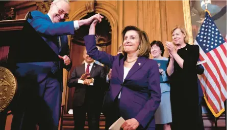  ?? ANDREW HARNIK/AP ?? Senate Majority Leader Chuck Schumer high-fives House Speaker Nancy Pelosi during a signing ceremony Thursday in Washington. Pelosi called the bill, which passed 258-169 in the House, a“triumph of love and freedom.”