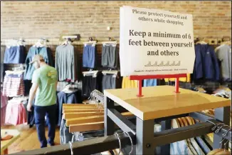  ??  ?? In this file photo, a sign reminding customers of social distancing is posted in the Bink’s Outfitters store in Murfreesbo­ro, Tennessee. U.S. consumer spending plunged 7.5% in March, reflecting the growing impact of the coronaviru­s pandemic as Americans complied with stay-at-home orders. (AP)