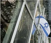  ?? /Reuters ?? Defiant: An Israeli flag hangs from the window of a high-rise apartment in Tel Aviv, Israel.
