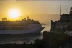  ?? DESMOND BOYLAN — THE ASSOCIATED PRESS ?? In this Feb. 4 2016 photo, the MSC Opera cruiser passes the Morro Fortress as the sun sets in Havana, Cuba. Cuban state media announced on Friday the loosening of a government policy that banned Cuban-born people from arriving by sea. Those...