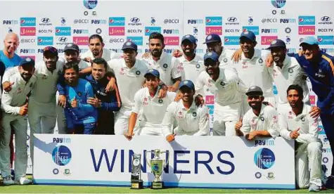  ?? AP ?? Indian team celebrate with trophy after defeating Bangladesh in the one-off Test match in Hyderabad yesterday. India won the match by 208 runs to extend their unbeaten run to 19 Tests.