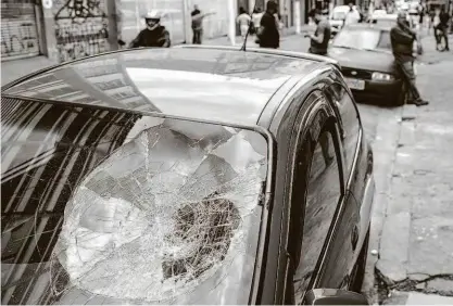  ?? Fotos Eduardo Anizelli/Folhapress ?? Vidro de carro danificado em quebra-quebra na rua Conselheir­o Nebias, em Campos Elíseos, na região central de São Paulo; quatro dos 11 veículos atingidos estavam em uma funilaria que funciona no local