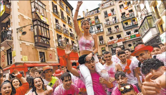  ?? Alvaro Barrientos The Associated Press ?? Revelers celebrate while waiting for the launch of the Chupinazo rocket to mark the official opening of the San Fermin festival in Pamplona, Spain, on Wednesday. Nine days of uninterrup­ted partying have begun in the city’s famed running-of-the-bulls festival.